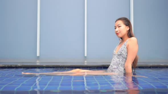 Young asian woman enjoy around outdoor swimming pool for leisure