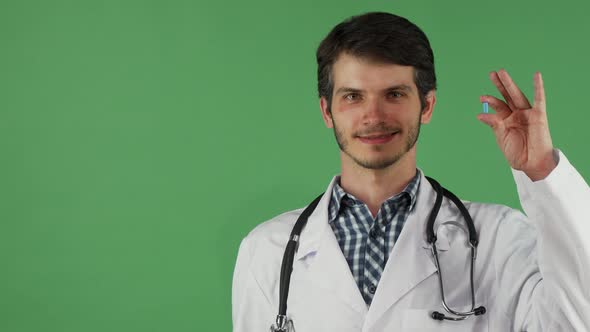 Cheerful Male Doctor Holding Vitamin Pill and an Apple