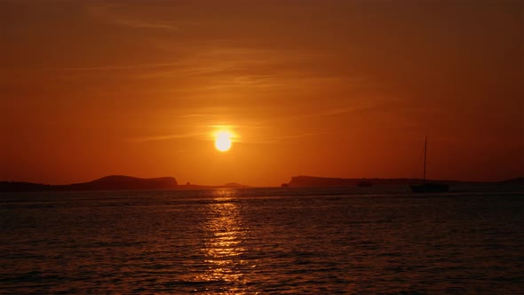 Small Boat Going Past Sunset in Ibiza 4K