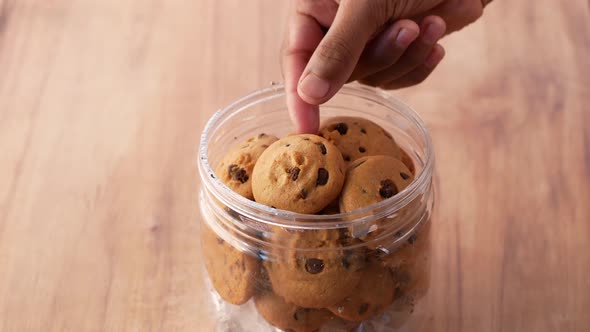 Hand Pick Sweet Cookies on Wooden Table