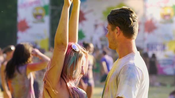 Seductive Young Female Dancing to Boyfriend, Couple Covered in Holi Colors