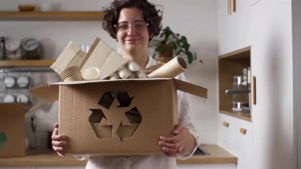 Satisfied Woman Holding A Box With Sorted Material For Recycling And Making Reusable Products