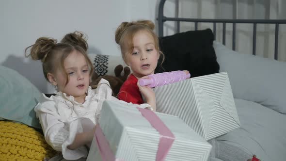 Happy American family celebrating Christmas. Children open a gift at home.