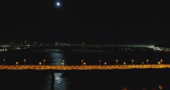 Night City Traffic on the Bridge Moon Path Reflected in the River Aerial View