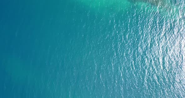 Natural fly over island view of a white sand paradise beach and aqua turquoise water background 