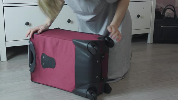 Unrecognizable Female Hands Checking Red Suitcase on Floor Home Ready to Go