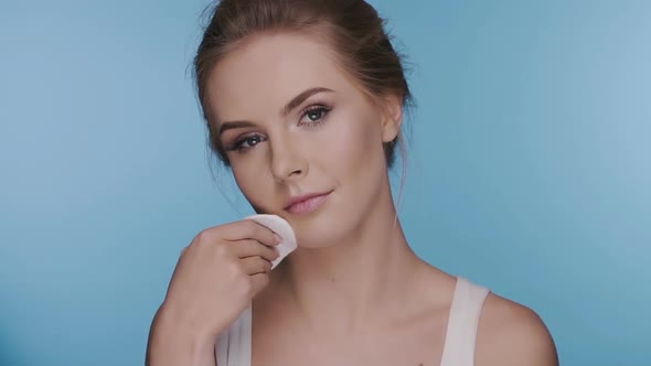 Woman Removes Make-up with White Sponge and Smiles