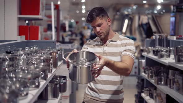 Man Choosing Cookware in Shopping Center