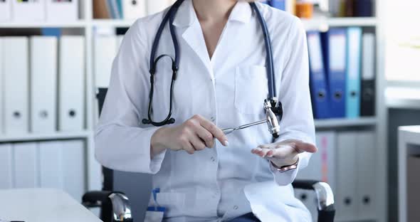 Neuropathologist Doctor in White Coat Holds Hammer at Workplace