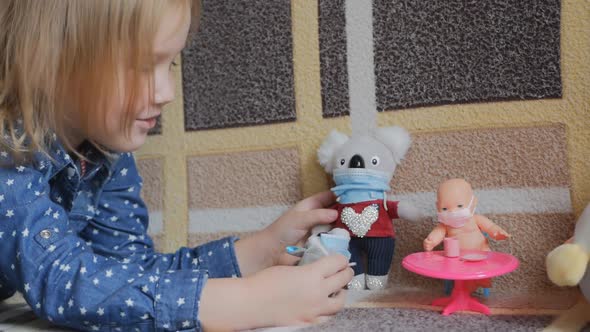 Caucasian Teenage Girl in a Blue Shirt Plays with Toys on the Couch