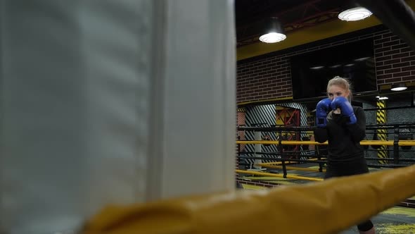 A Beautiful Young Active Woman Trains in a Boxing Ring She Practices Punches