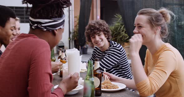 Slow motion shot of friends eating Asian takeaway food outdoors