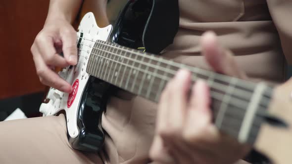 Closeup of a man practicing playing the guitar Spot focus has a beautiful scene