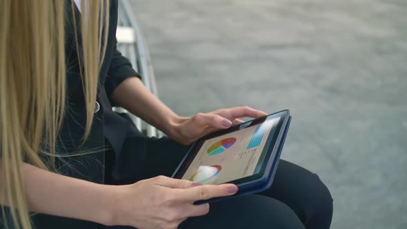 Woman Using Tablet on Bench. Formal Business Woman Sitting on Bench in Office Patio and Browsing