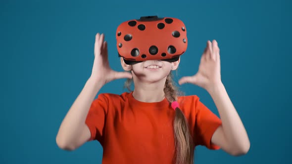 Girl Takes Off VR Goggles and Makes Face at Blue Wall