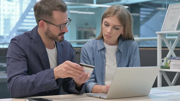 Male and Female Professionals Having Online Payment Failure on Laptop