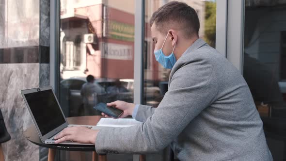 Business Man Wearing Face Mask Working with Laptops in Cafe