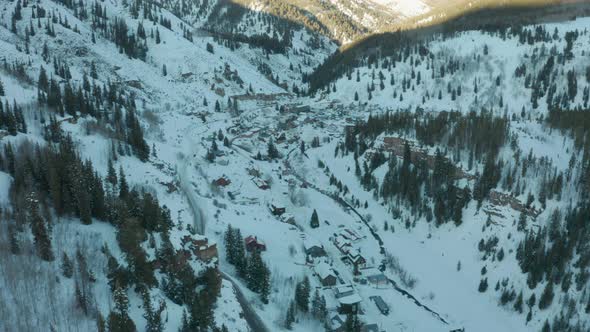 Aerial Drone Shot Approaching Small Mountain Town in Snowy Colorado Valley