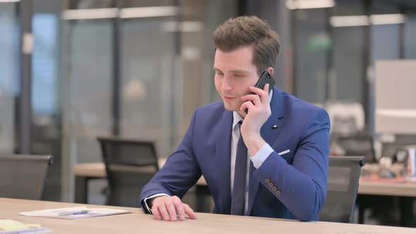 Businessman Talking on Phone in Office