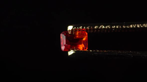 Natural Hessonite Brown Garnet Gemstone in the Tweezer on the Turn Table