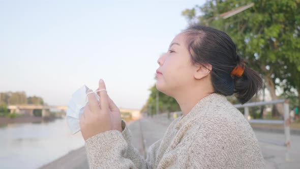 Close up of Asian woman standing and taking deep  breath by the river