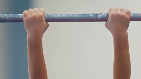 Kids Gymnastic Tournament  Young Boy Does Exercises on the Turnstile