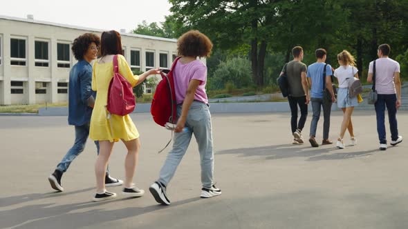 Students Walking in Groups Against College Building