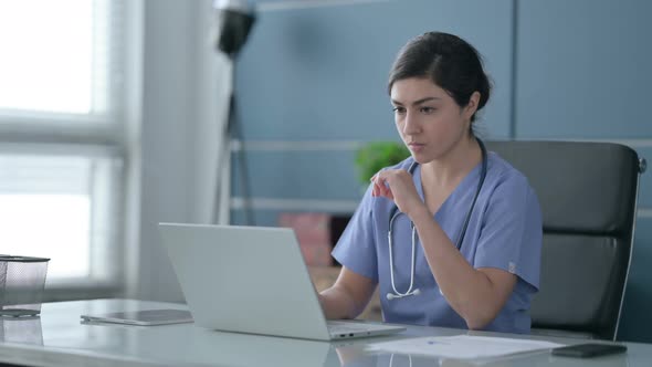 Indian Female Doctor Thinking while Working on Laptop in Office