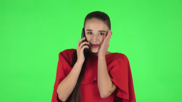 Portrait of Pretty Young Woman Is Talking for Mobile Phone and Rejoicing. Green Screen