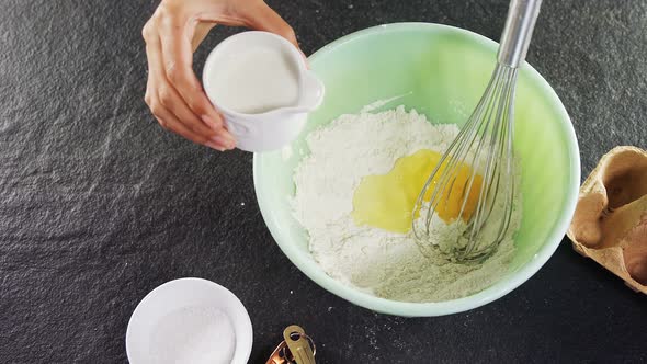 Woman mixing milk in flour