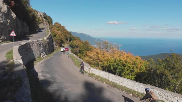 Aerial Shot: Group of Cyclists Riding Their Bicycles on Mountain Highway