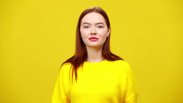 Portrait of Beautiful Redhead Woman Posing at Yellow Background Looking at Camera Smiling