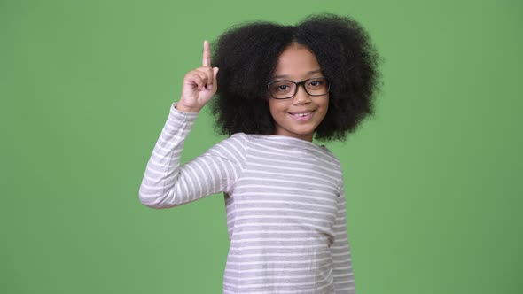 Young Cute African Girl with Afro Hair Showing Something