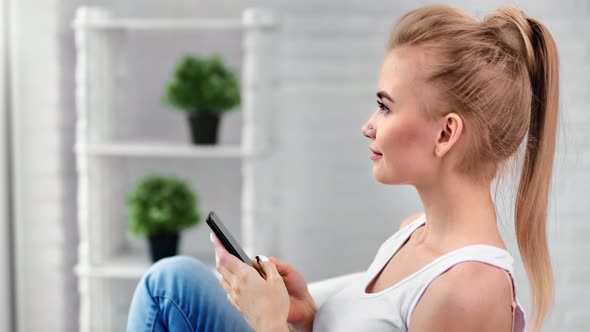 Pleasant Girl Chatting Use Smartphone Relax at Home