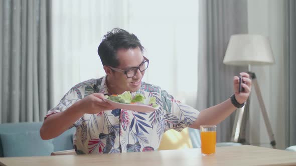 Man Holding A Dish Of Healthy Food And Taking Selfie With Smartphone While Preparing Healthy Food