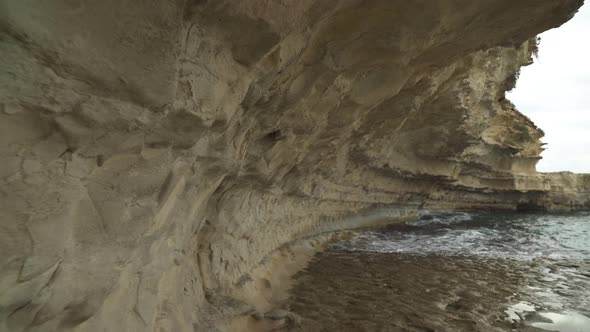 Limestone Wall near Il-Kalanka Beach in Malta with Splashing Water in Bay