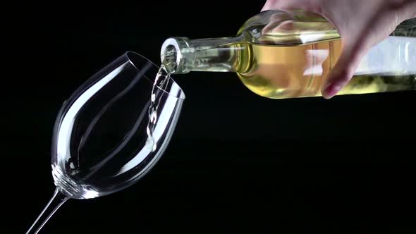 White Wine Being Poured Into a Wineglass, Black, Closeup, Slowmotion