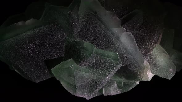 A large specimen of fluorite shimmers in green and bluegreen.