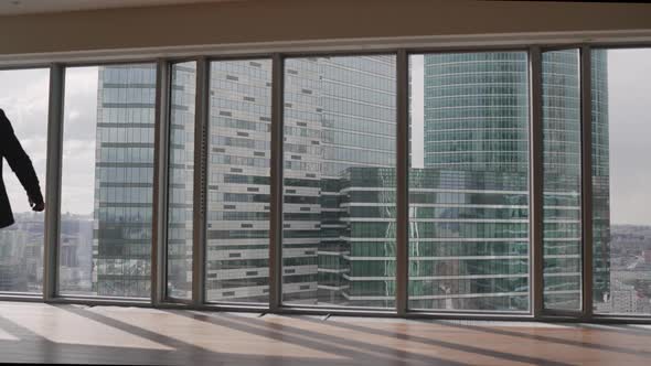 Confident Businessman in a Suit Contemplating Business Deal in His Office Looking Out of the Window