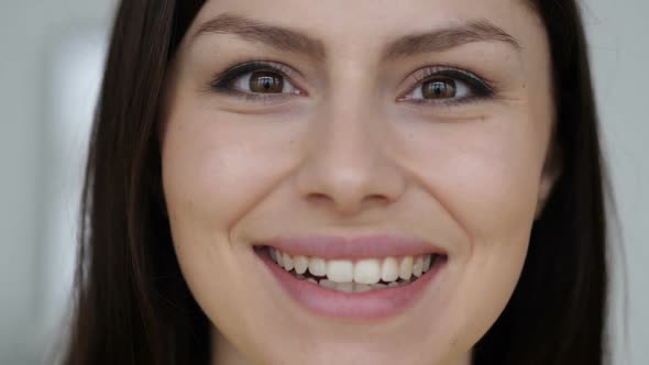 Close Up of Smiling Face of Young Woman Looking at Camera