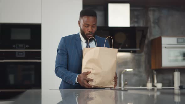 Young African Businessman Coming Back Home with Groceries Bags