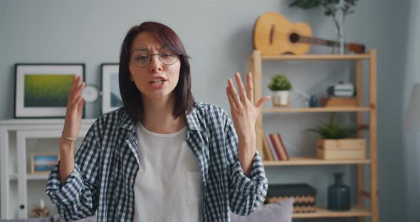 Portrait of Angry Young Woman Yelling Looking at Camera Gesturing Waving Hands