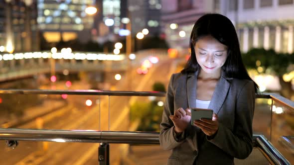 Business woman working on mobile phone at night 