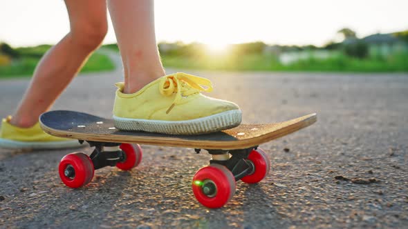 Close Up of Child Foot in Sneaker on Skateboard in Motion Boy Skater Riding at Sunset