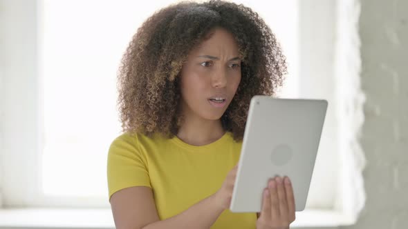 African Woman Reacting to Loss on Tablet in Office
