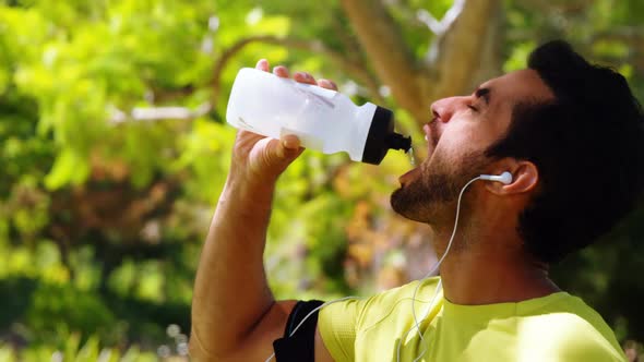 Male jogger drinking water from bottle 4k