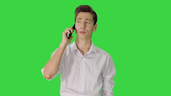 Handsome Man Having Phone Talk While Walking on a Green Screen, Chroma Key.