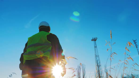 Silhouette Mature Engineer Working with Satellite Dish Telecom Network in Telecommunication Tower on