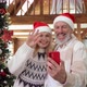 Happy Mature Couple in Santa Hats Greeting Family on Phone Christmas Video Call - VideoHive Item for Sale