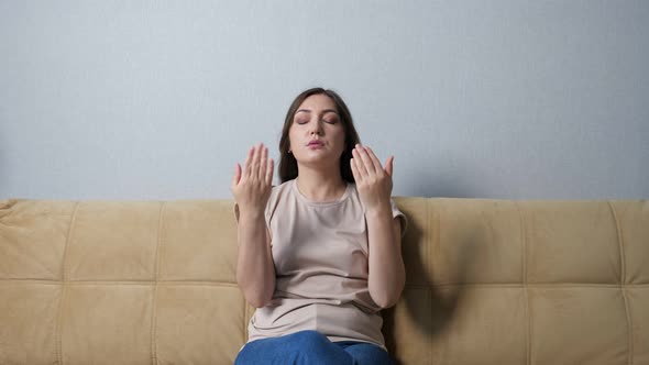 Young Woman Suffering From Heat While Sitting on Sofa at Home